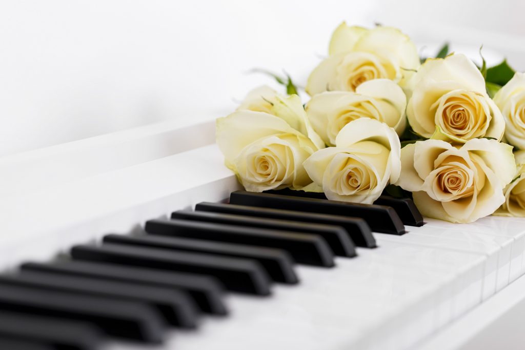 Pianist uitvaart boeken of inhuren, piano met witte rozen voor afscheid
